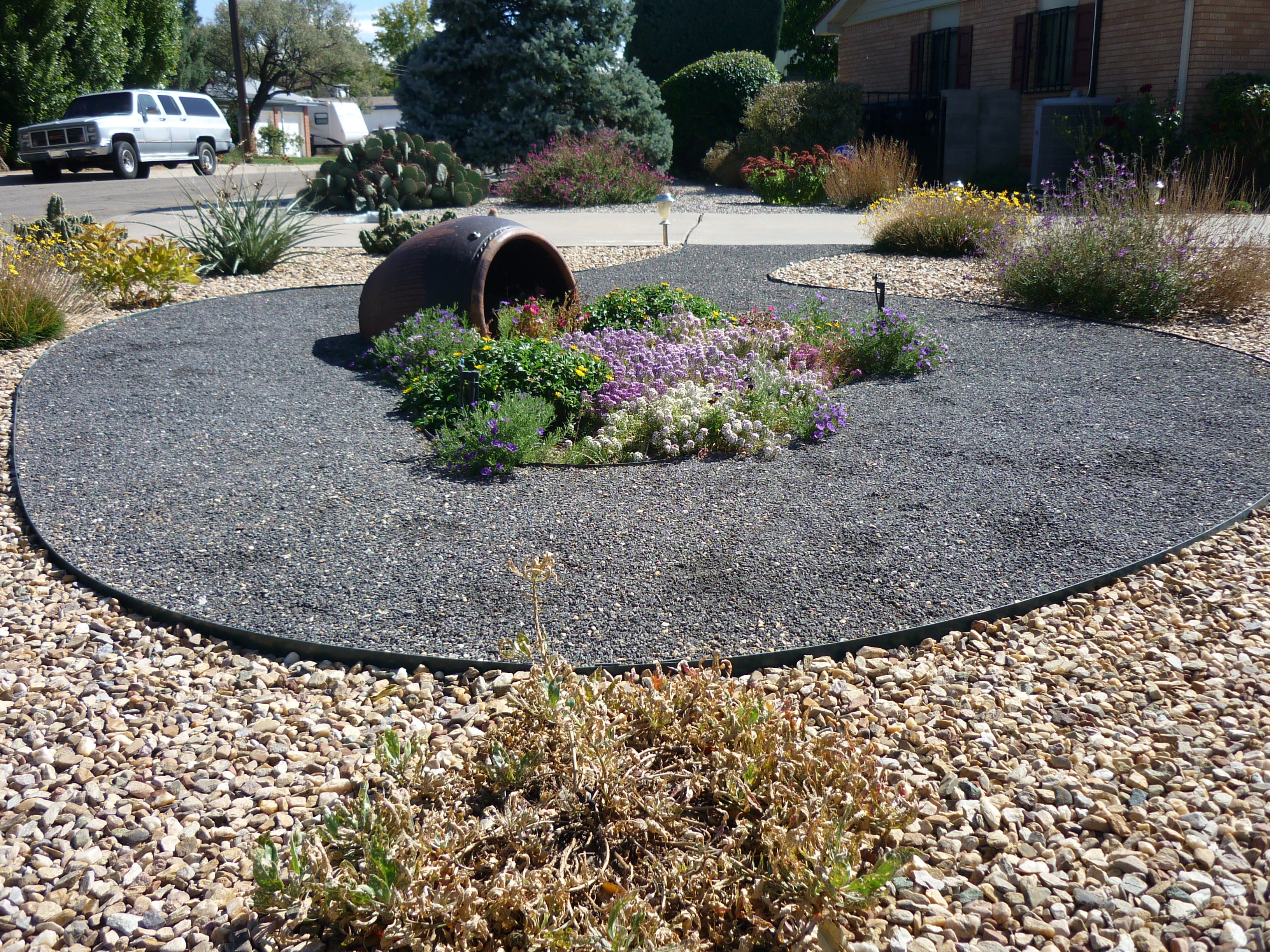 Decorative circular garden bed with barrel planter